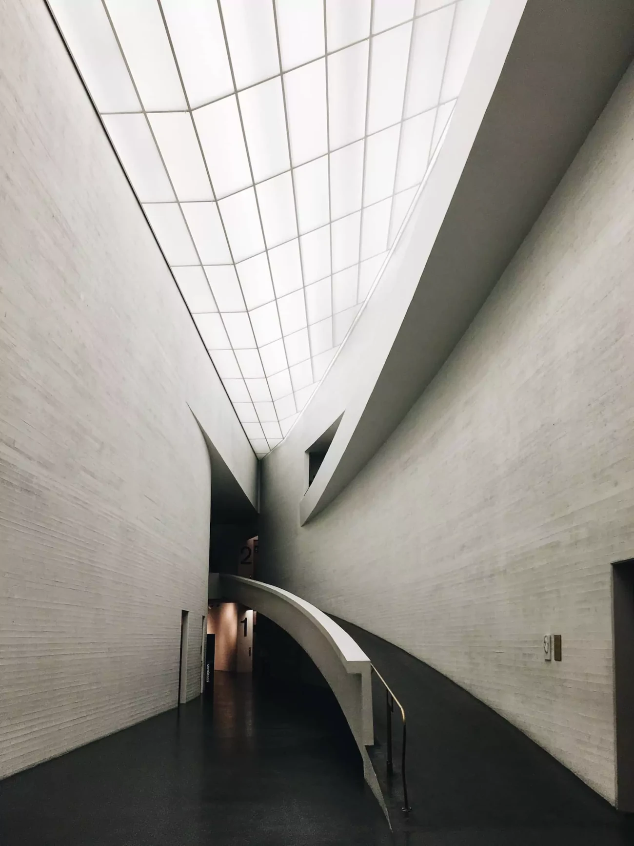 Modern architectural hallway with curved ceiling.